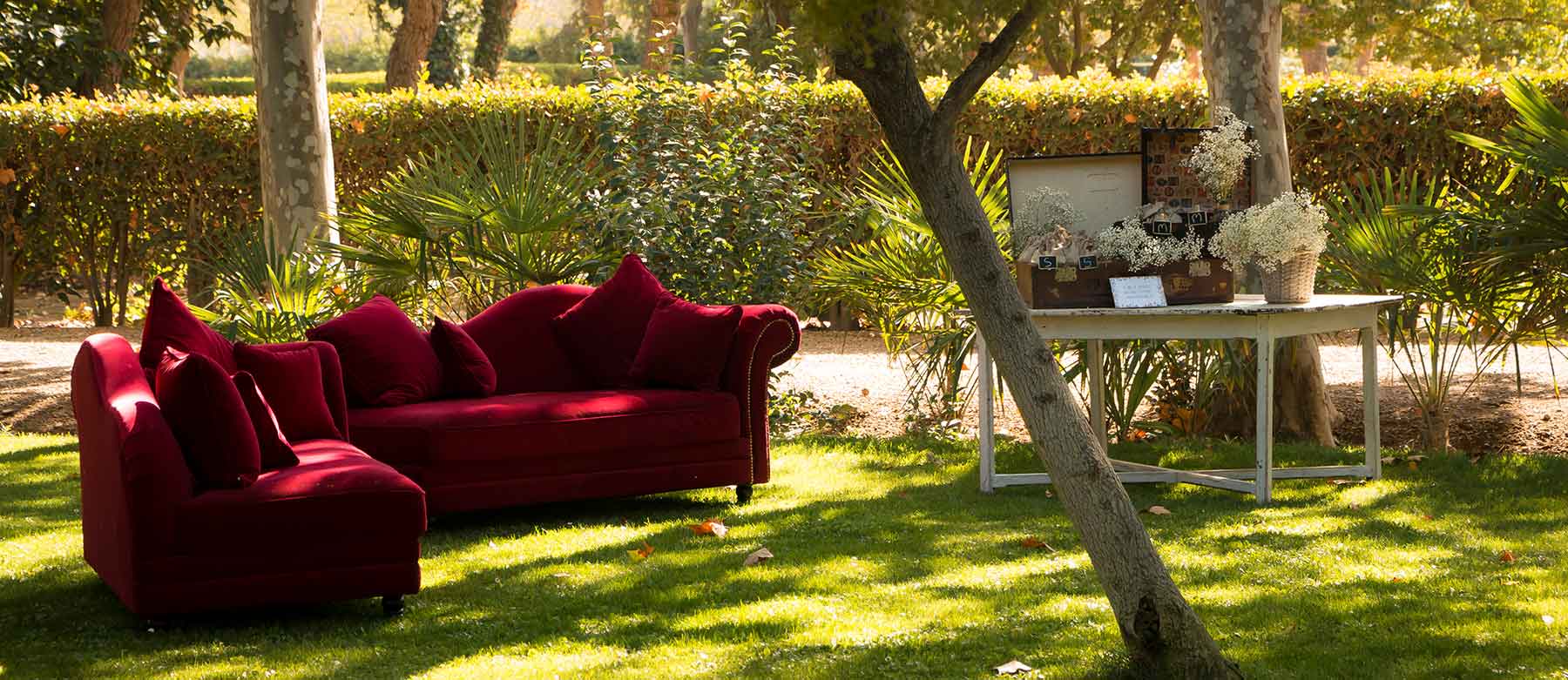 Zona exterior del jardín con invitados en coctel y fuente en primer plano
